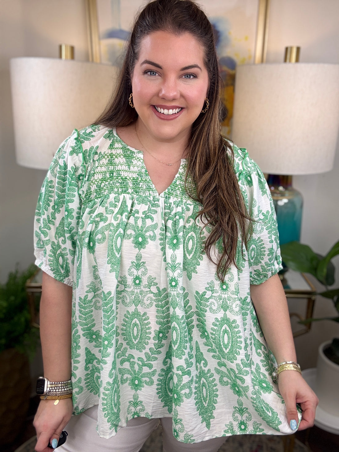 Woman in a green and white print top.