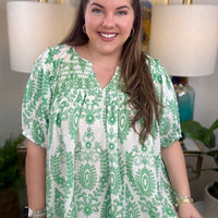 Woman in a green and white print top.