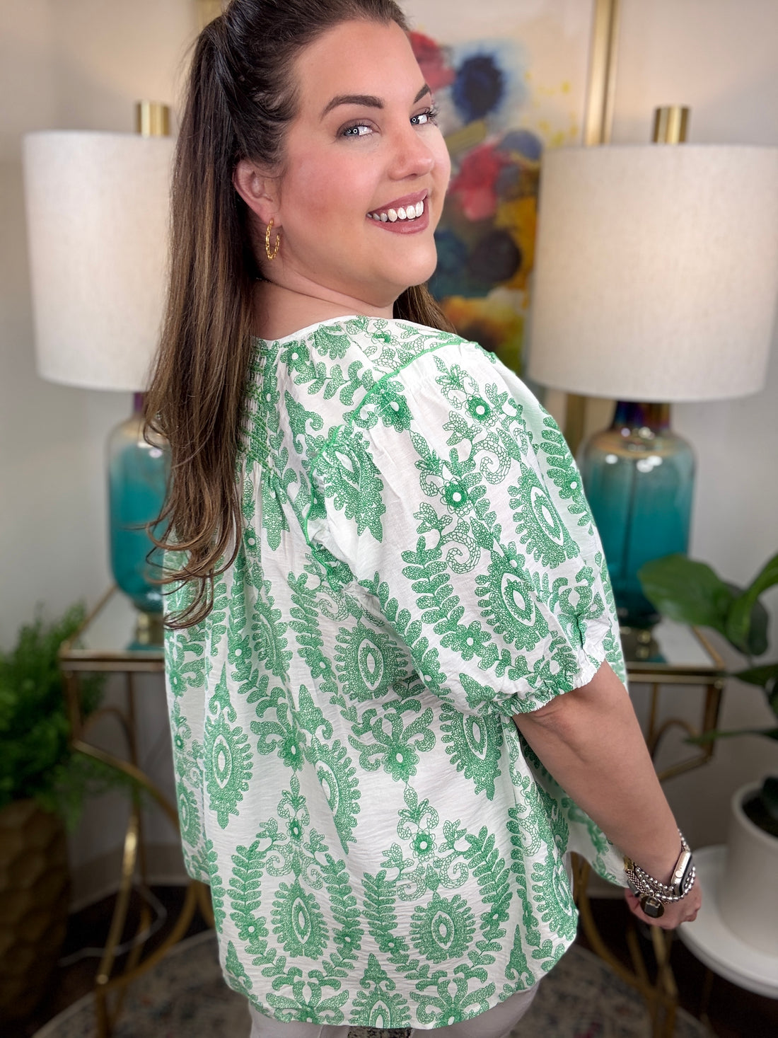 Woman in a green and white print top.