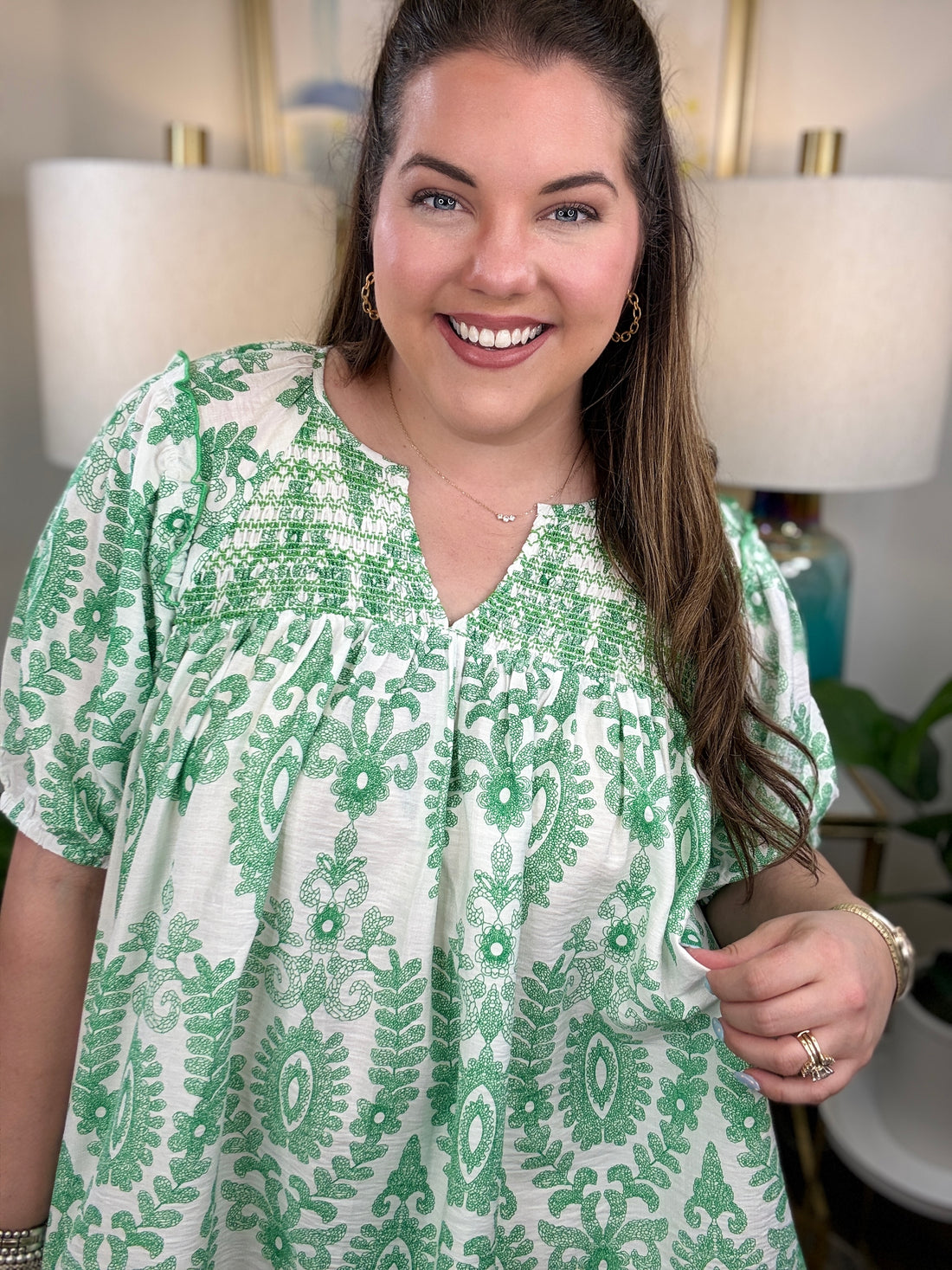 Woman in a green and white print top.
