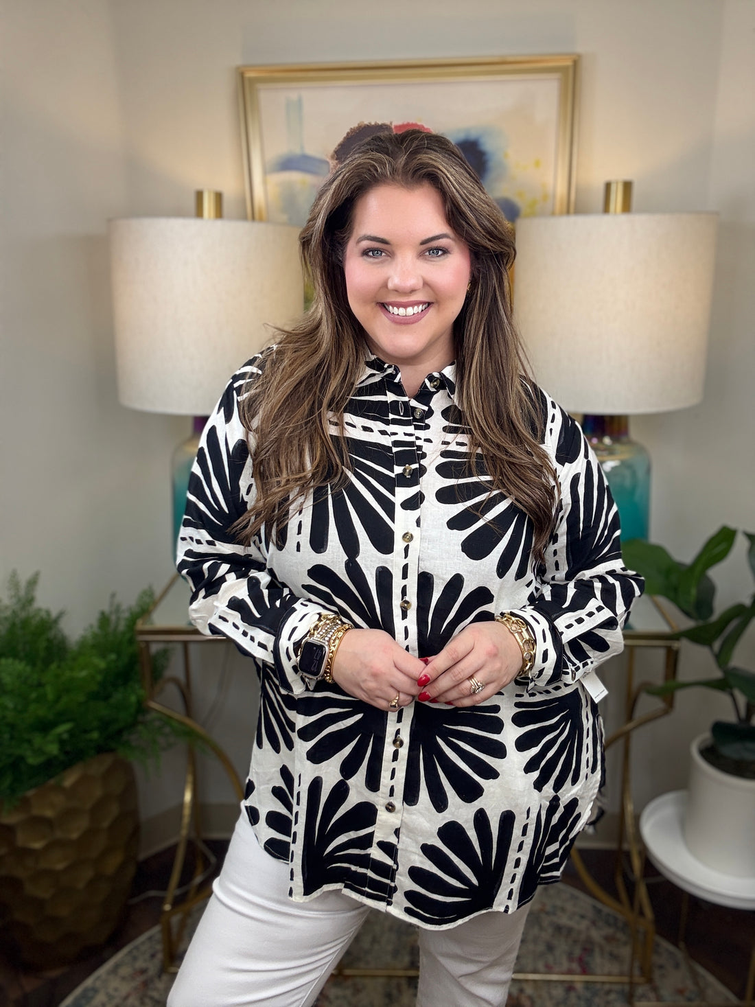 Woman wearing a black and white patterned blouse.