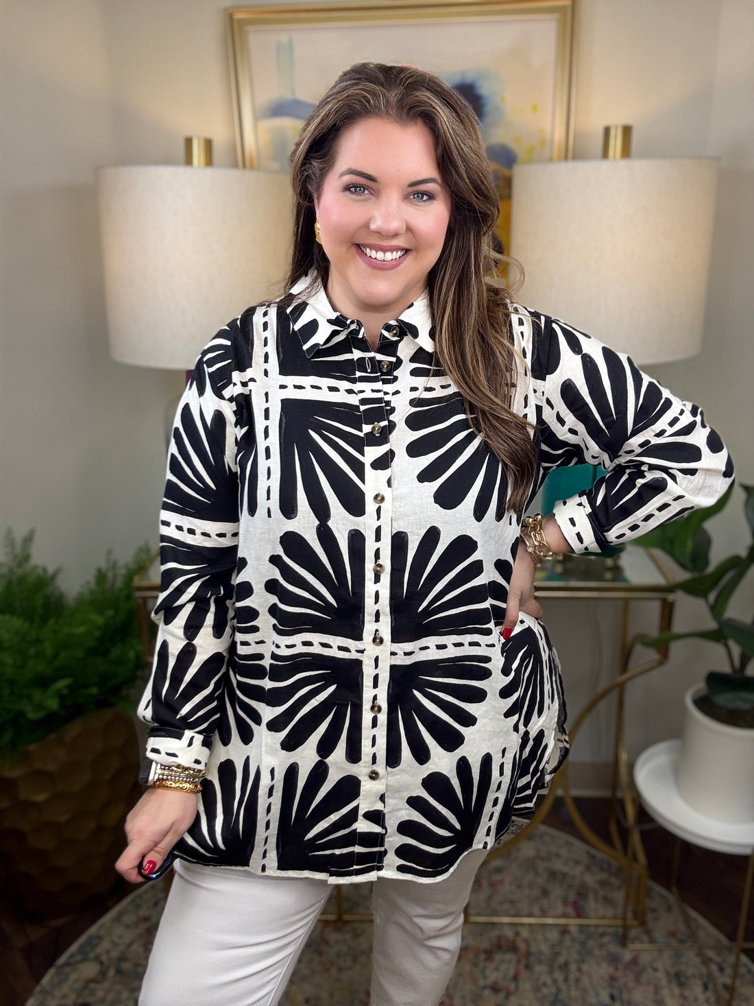 Woman wearing a black and white patterned blouse.