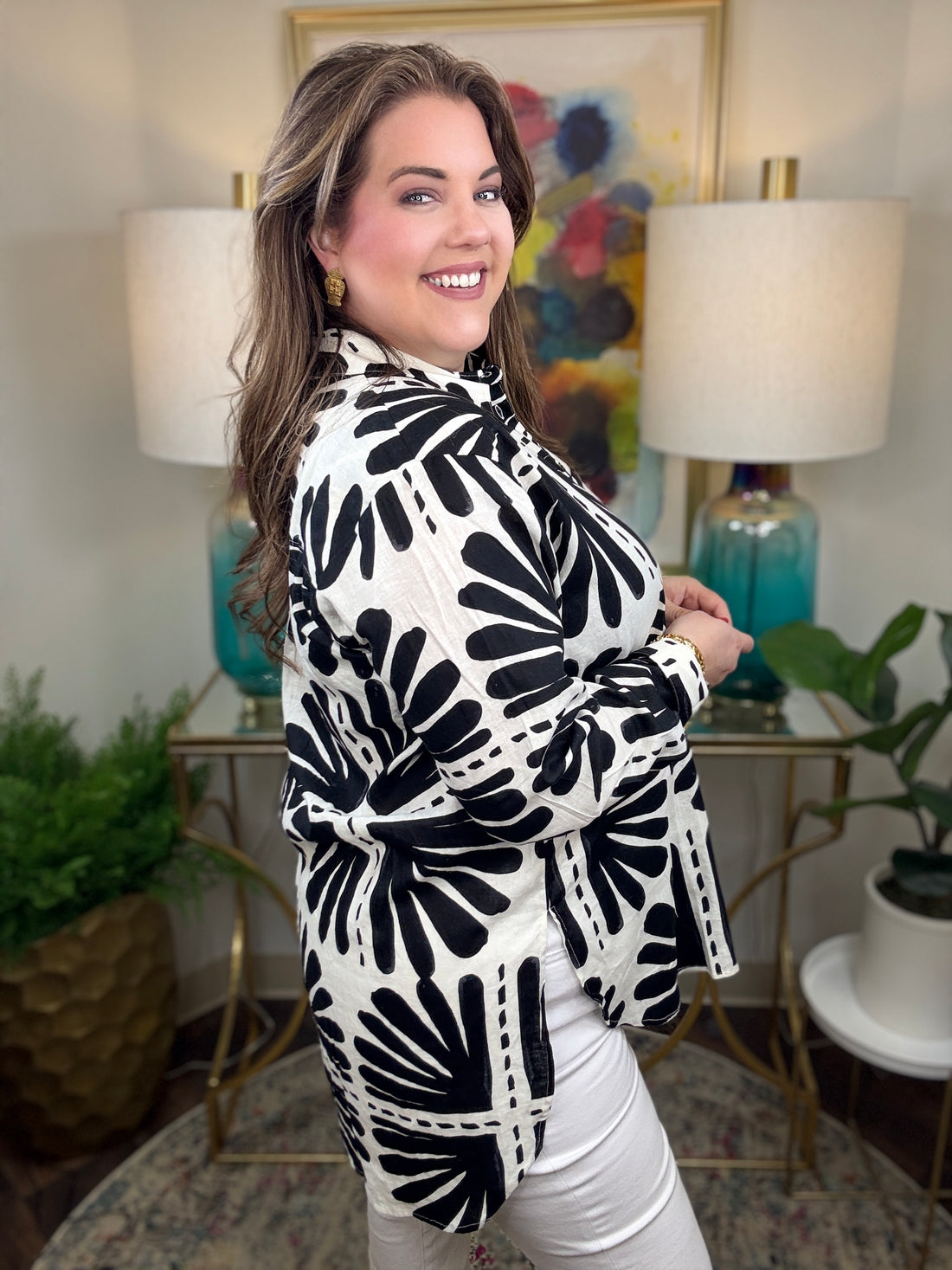 Woman wearing a black and white patterned blouse.