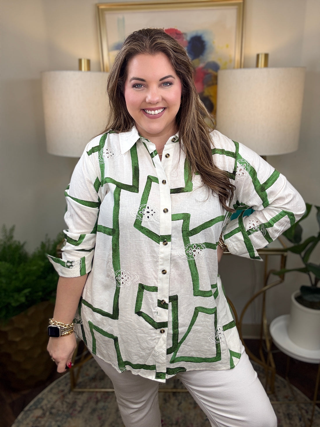 Woman wearing a white shirt with green zigzag pattern.