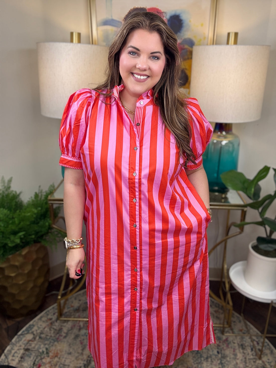 Woman wearing a red and pink striped maxi dress. 