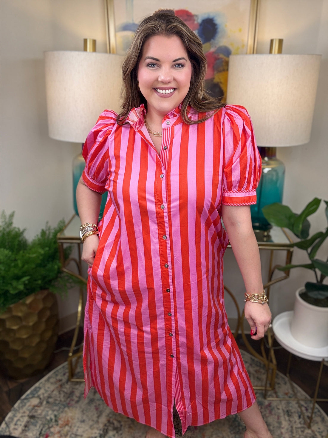 Woman wearing a red and pink striped maxi dress. 