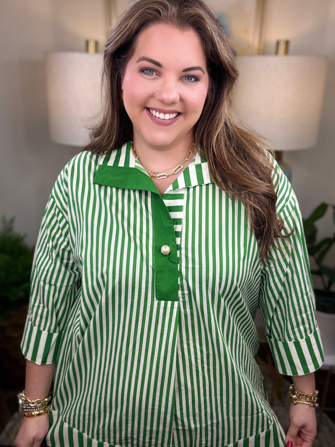 Woman wearing a green and white striped shirt with pearl button