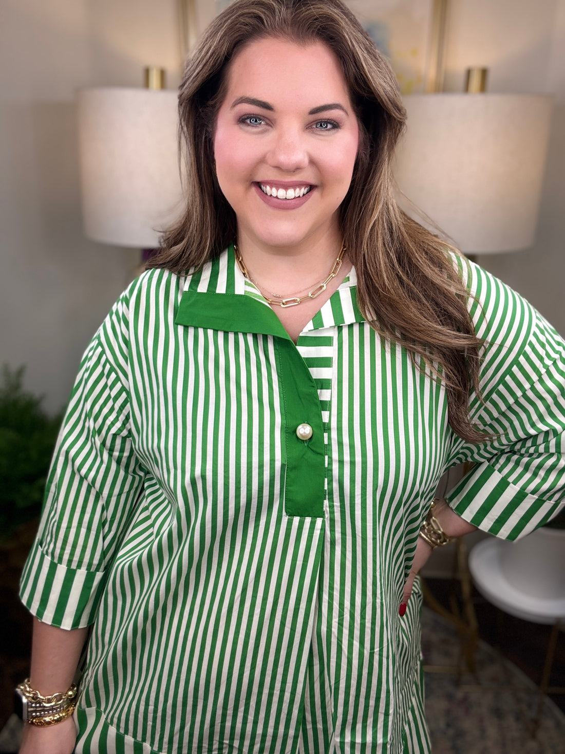 Woman wearing a green and white striped shirt with pearl button