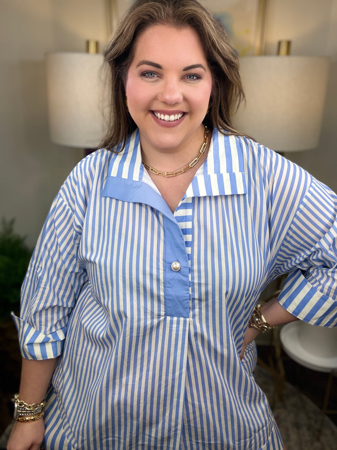 Woman wearing a blue and white striped shirt with pearl button
