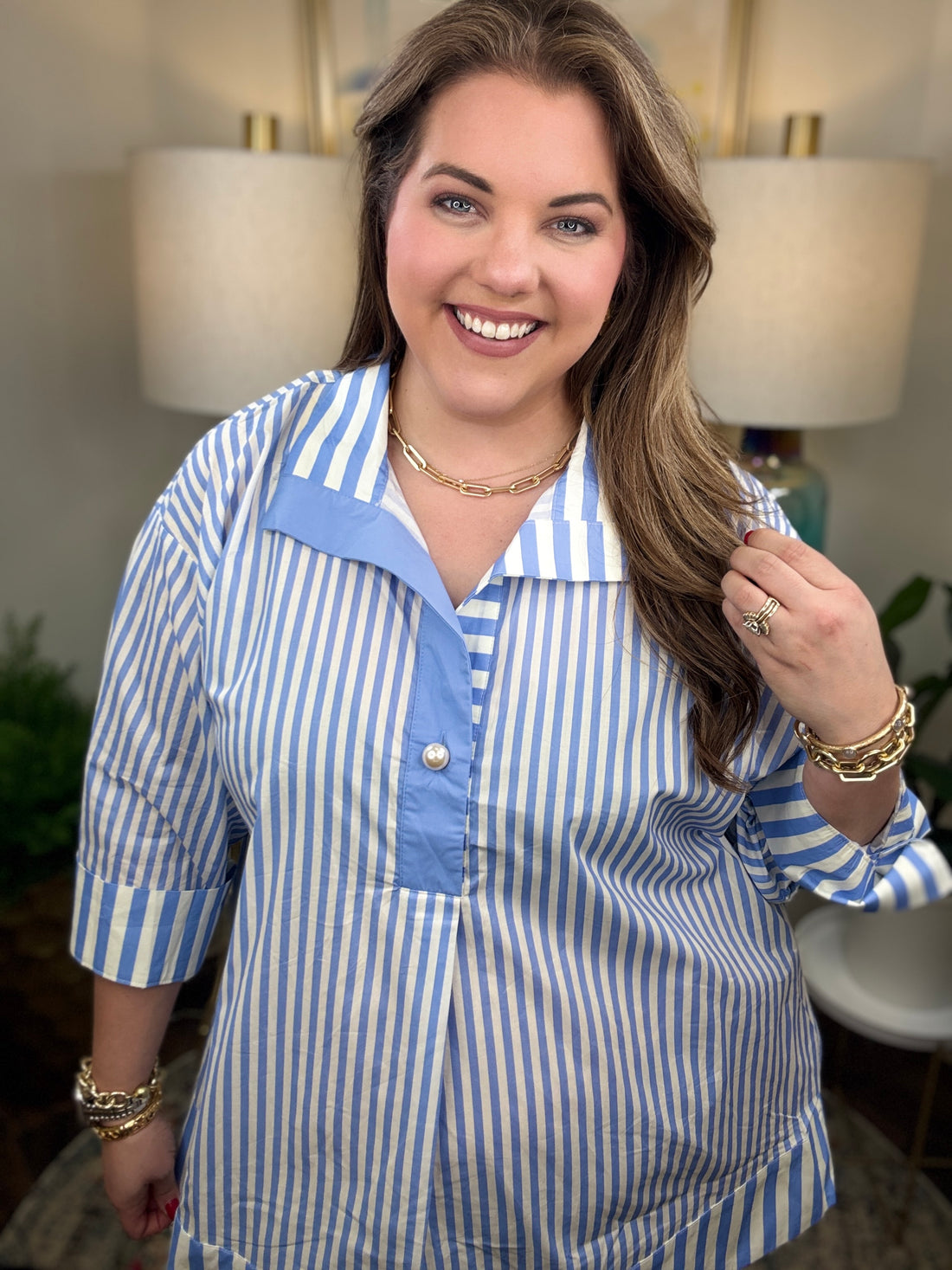 Woman wearing a blue and white striped shirt with pearl button