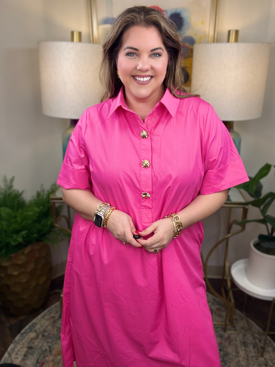 Woman wearing a pink dress with gold accent buttons