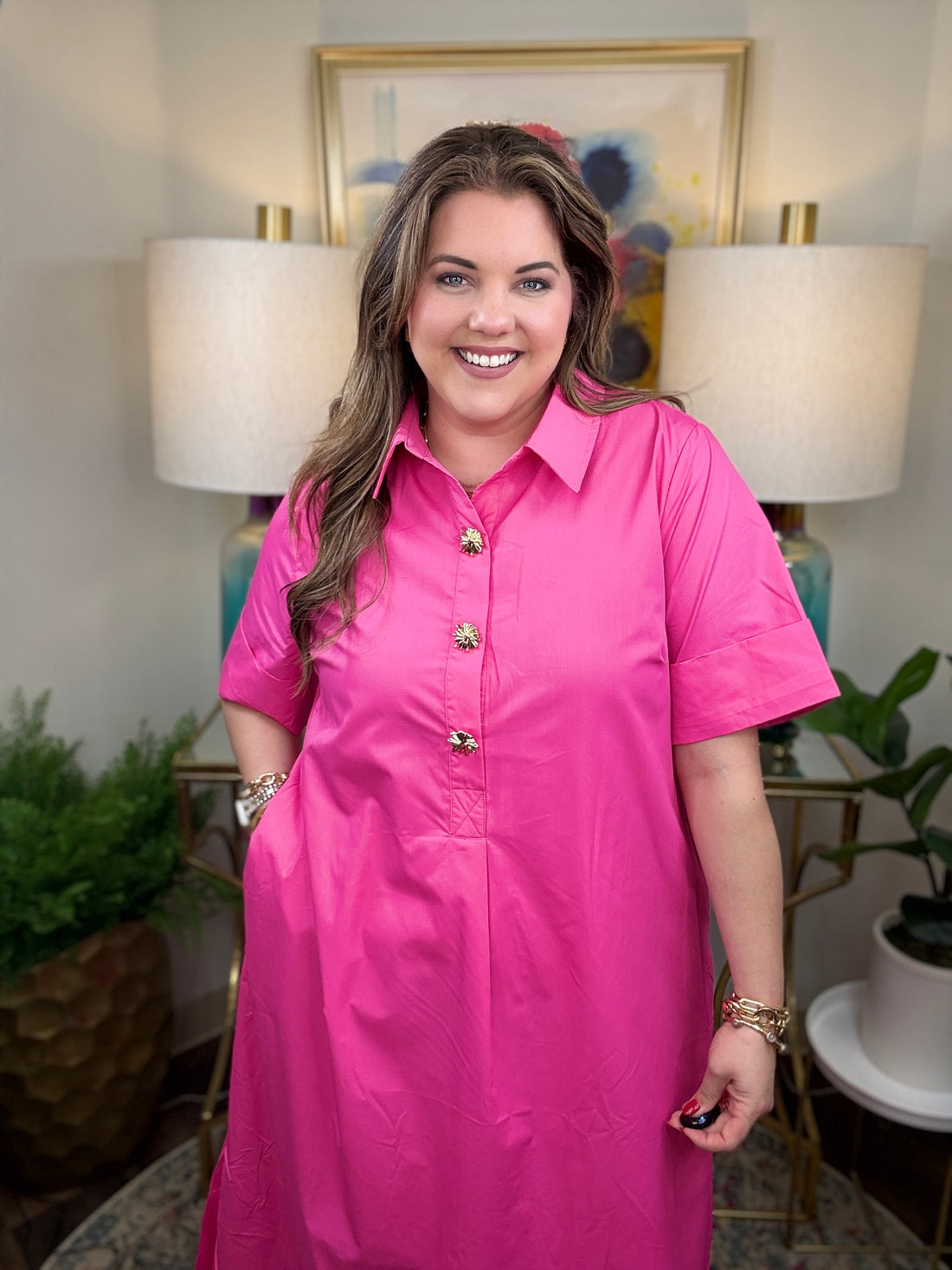 Woman wearing a pink dress with gold accent buttons