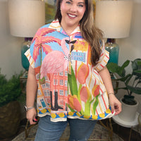  Woman wearing a top with whimsical flamingo print with tropical details.