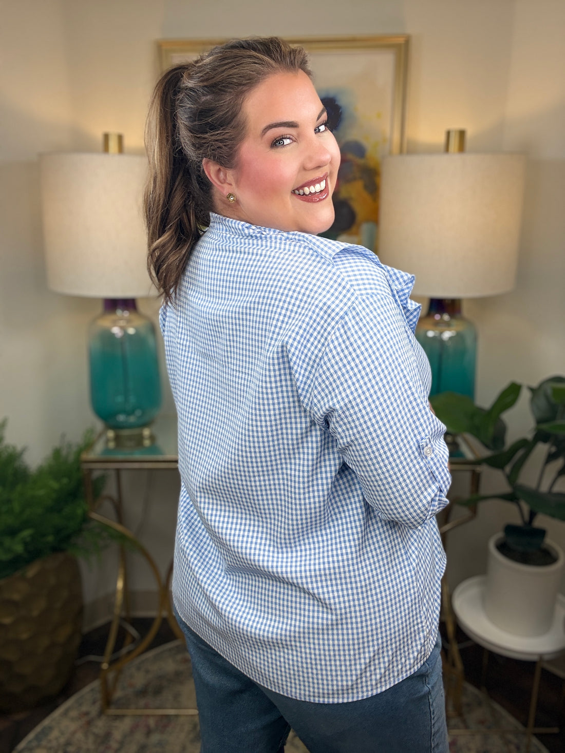 Woman wearing a blue checkered blouse with ruffles