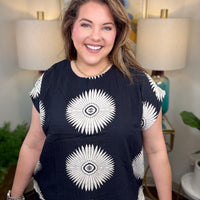Woman wearing a black top with white starburst design
