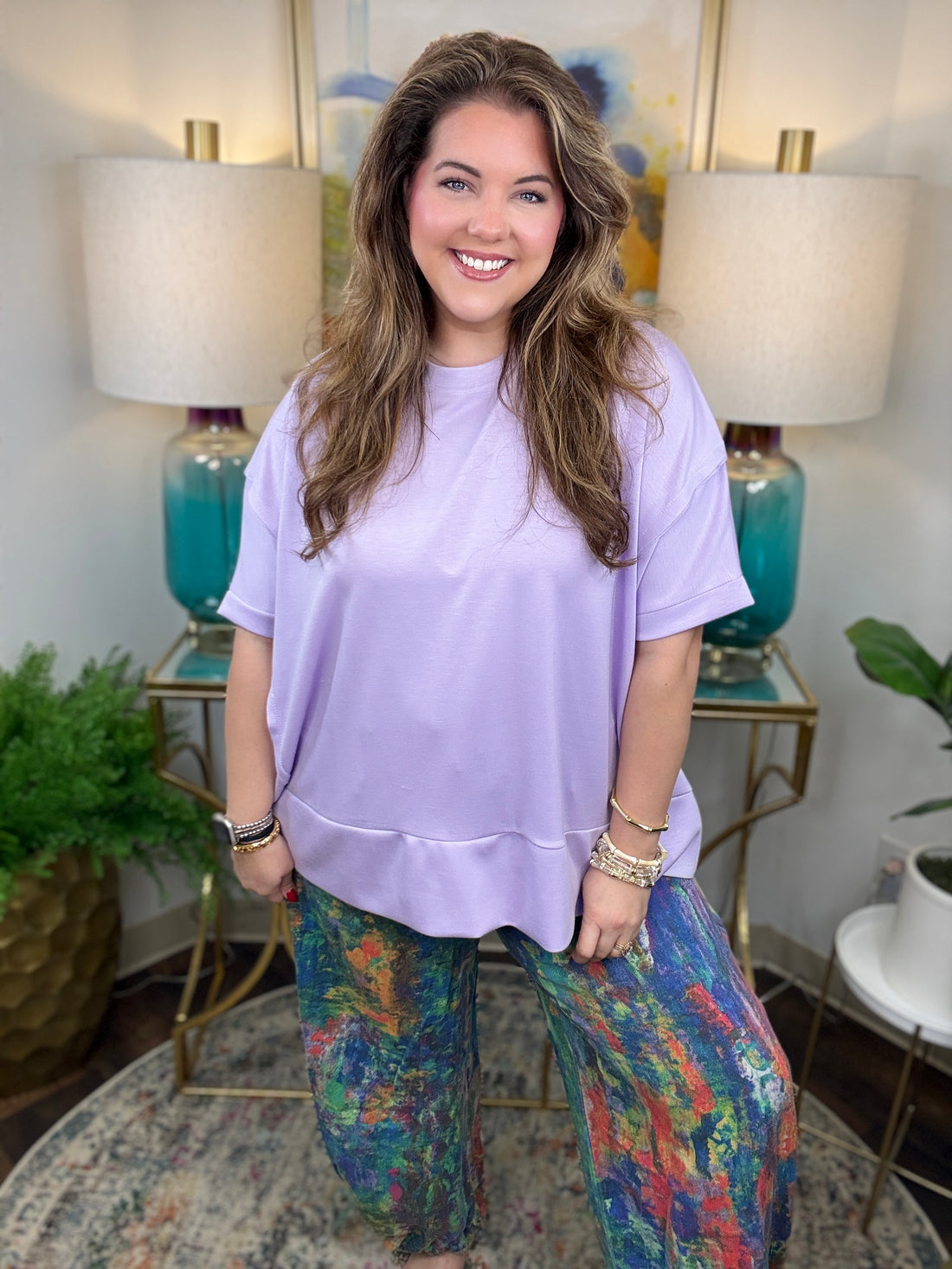 Woman wearing colorful denim pants with vibrant brush stroke pattern. 