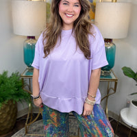 Woman wearing colorful denim pants with vibrant brush stroke pattern. 