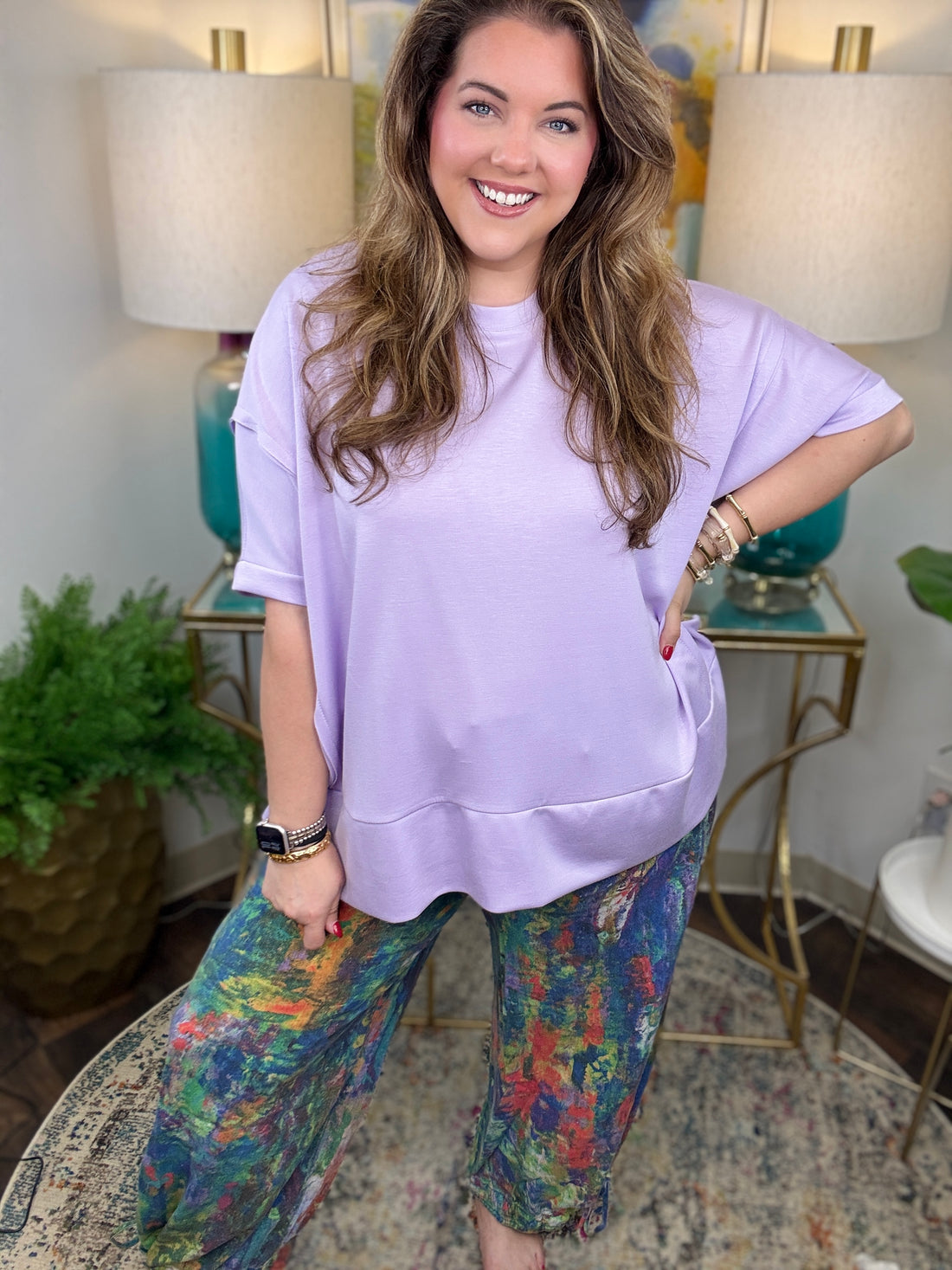 Woman wearing colorful denim pants with vibrant brush stroke pattern. 
