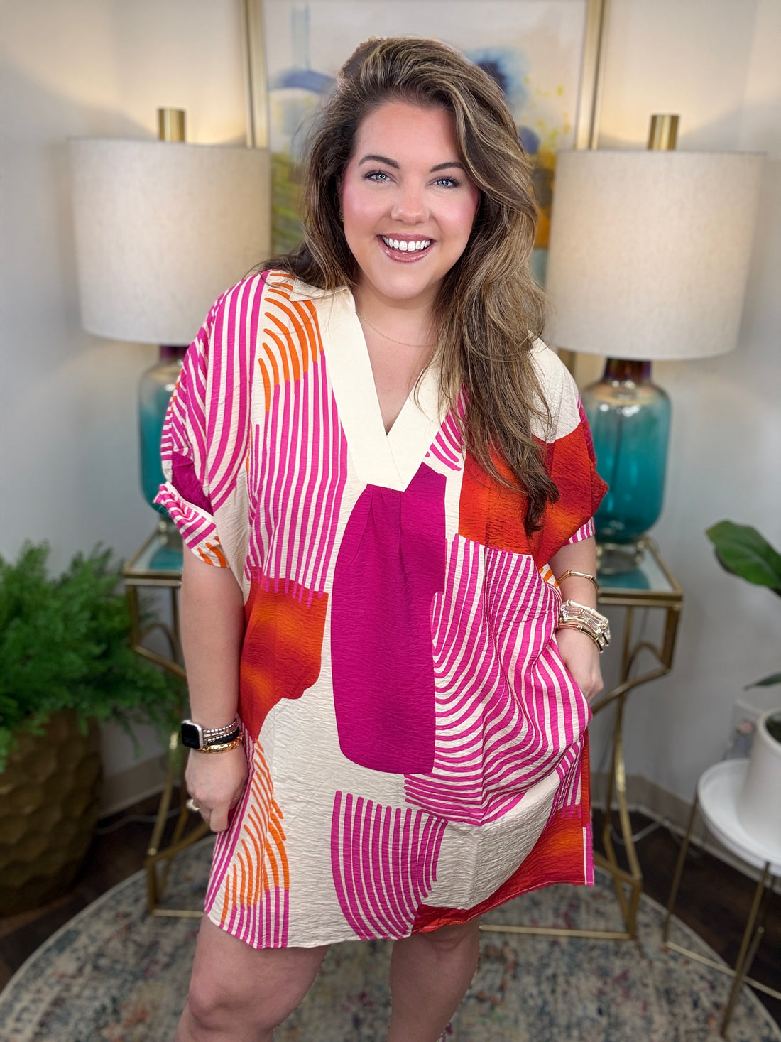 Woman wearing a magenta, orange and cream geometrical dress