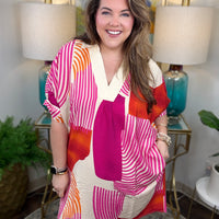 Woman wearing a magenta, orange and cream geometrical dress