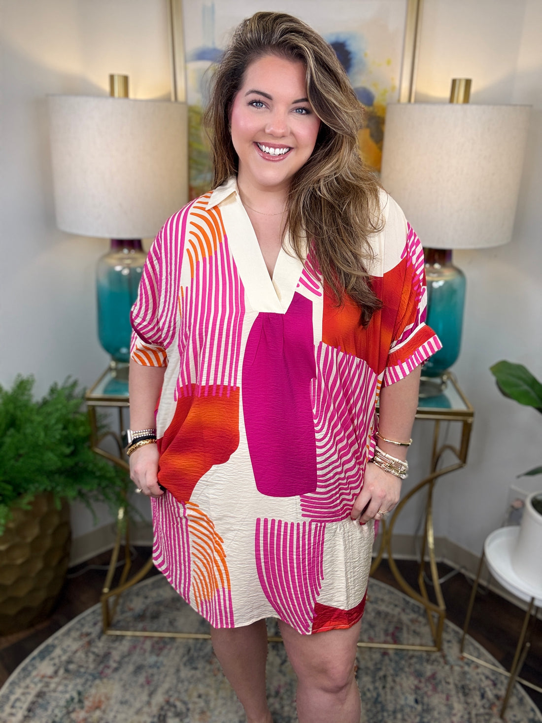 Woman wearing a magenta, orange and cream geometrical dress