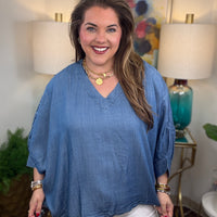 Woman wearing a denim v-neck dolman sleeve blouse