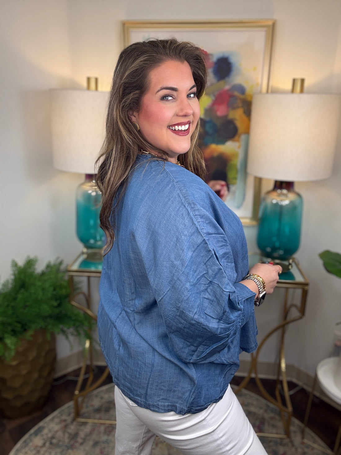 Woman wearing a denim v-neck dolman sleeve blouse
