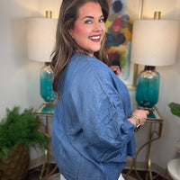 Woman wearing a denim v-neck dolman sleeve blouse