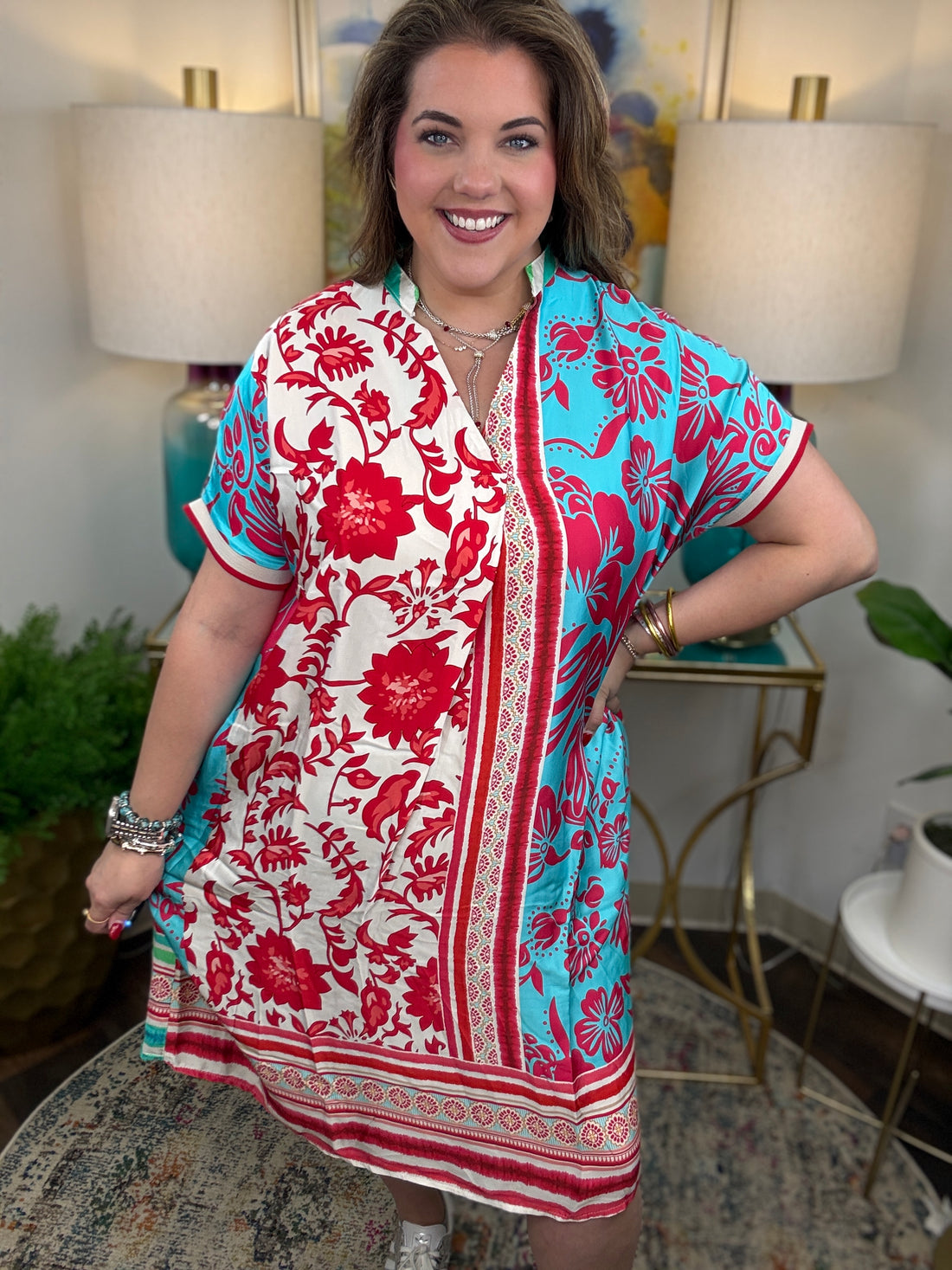 Woman wearing a colorful dress with floral patterns in a home setting