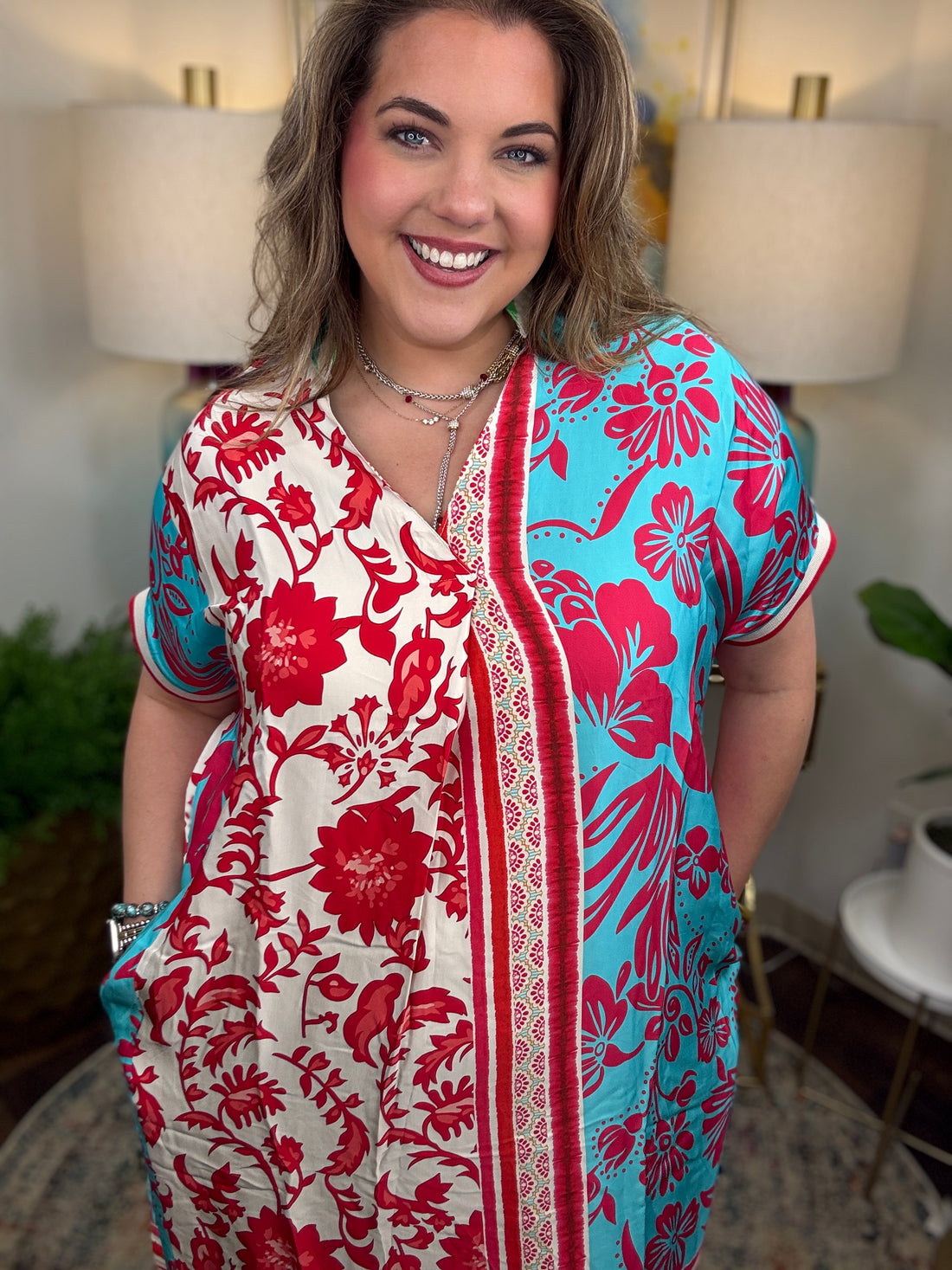 Woman wearing a colorful floral dress in an indoor setting