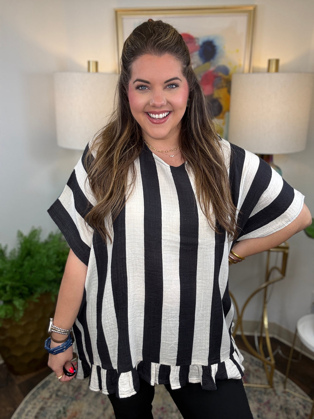 Woman wearing a cream and black striped oversized top 