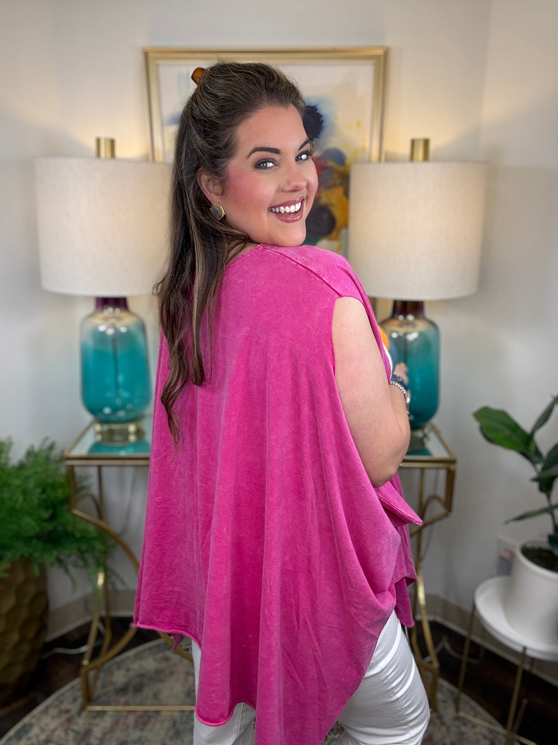 woman wearing a sleeveless bright pink top with a large colorful Frida Kahlo graphic print on the front