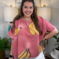 Woman wearing a pink short-sleeve top with a yellow banana print