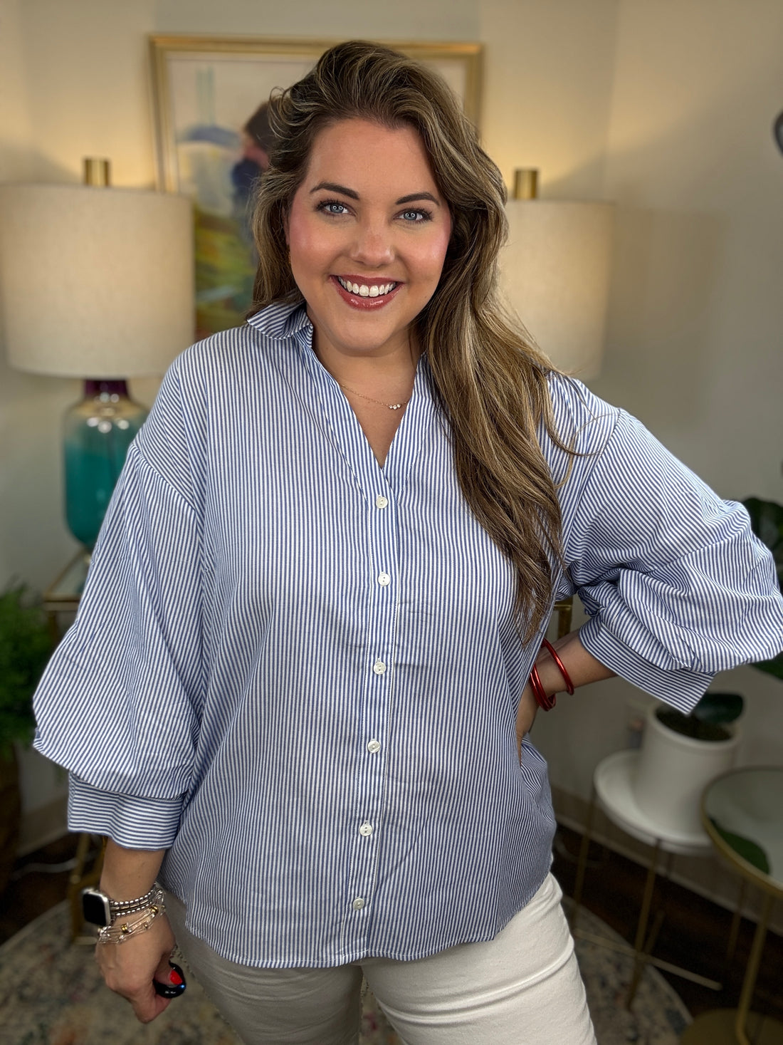 A woman wearing a light blue and white vertically striped button-down shirt