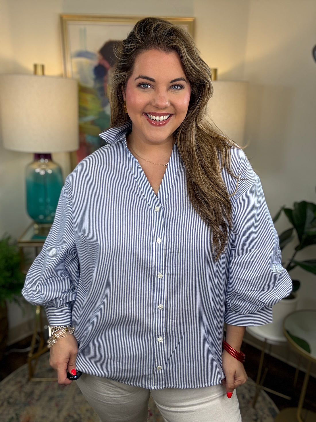 A woman wearing a light blue and white vertically striped button-down shirt