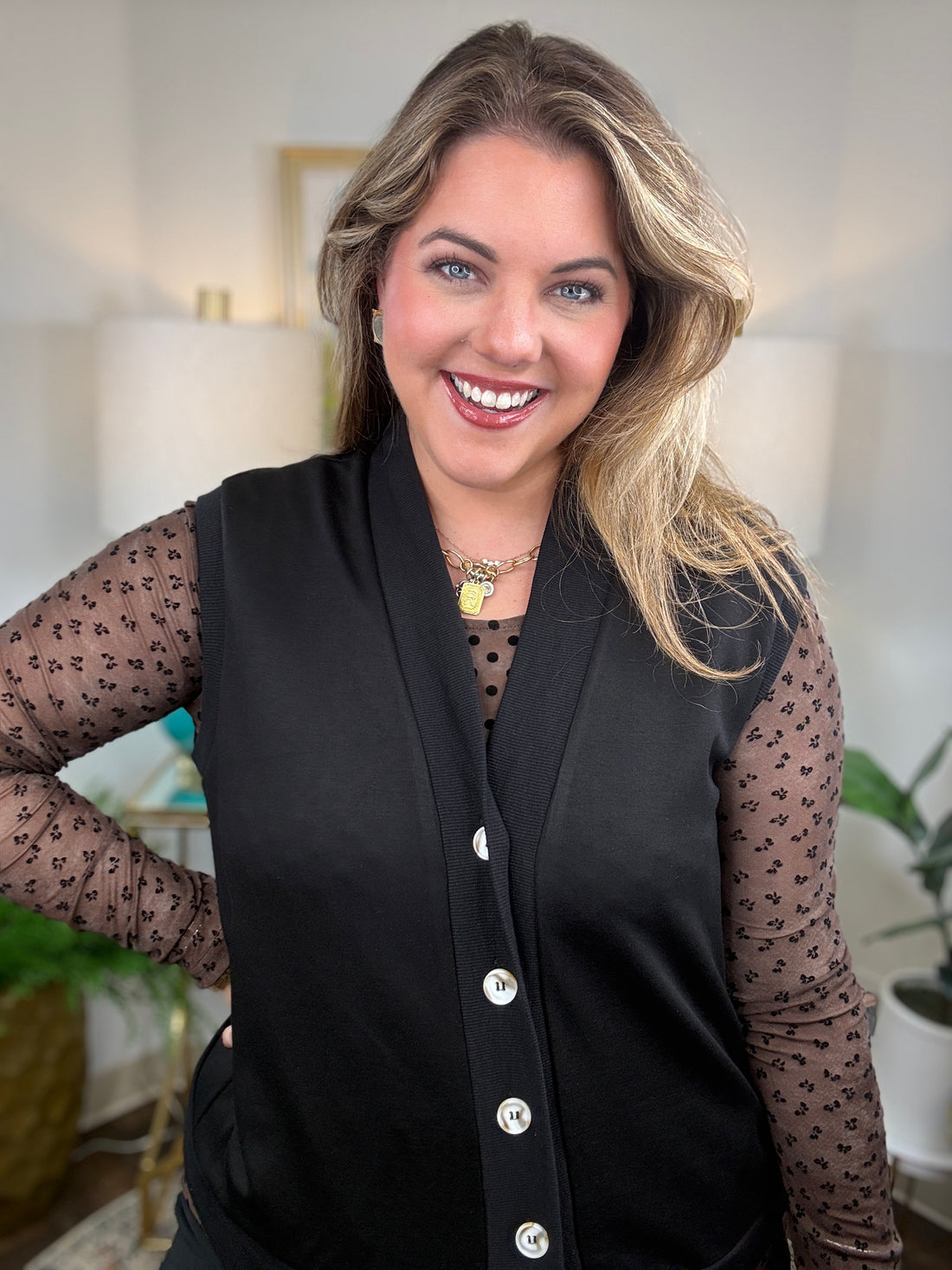 Brown mesh top with polka dot bodice and floral sleeve detail layering with black vest